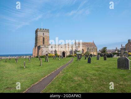 Bamburgh, Northumberland, Royaume-Uni, 21 juillet 2021 - Eglise St Aidens et cimetière le jour ensoleillé avec ciel bleu. Banque D'Images