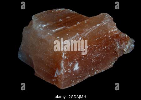 cube de calcite orange brut isolé sur fond noir Banque D'Images