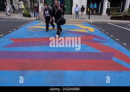 Avec de nombreuses personnes et familles séjournant au Royaume-Uni pour leur séjour d'été pendant les vacances scolaires, un grand nombre de touristes domestiques, Qui aurait normalement voyagé à l'étranger, ont decended dans la capitale pour voir les sites, comme vu ici à Piccadilly Circus, alors que les gens traversent le nouveau graphique et à motifs des passages pour piétons multicolores le 10 août 2021 à Londres, au Royaume-Uni. Après le coronavirus / Covid-19 santé peur des deux dernières années, et avec quelques restrictions de voyage toujours en place, plus de personnes ont choisi une staycation qui est un séjour dans les pays d'origine r Banque D'Images