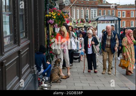 Windsor, Berkshire, Royaume-Uni. 12 août 2021. Une dame donne un peu d'argent à un homme mendiant dans la rue avec son chien. Crédit : Maureen McLean/Alay Live News Banque D'Images