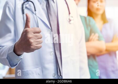 Médecin équipe médicale avec les pouces de la main vers le haut signe positif pour les bons soins confirmer le concept de santé de service protégé de virus. Banque D'Images