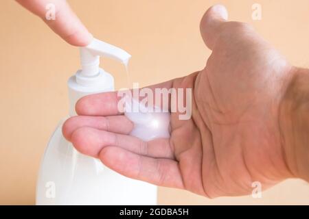 Bouteille de savon liquide et pression sur le distributeur, savon sur la paume. Se laver les mains Banque D'Images