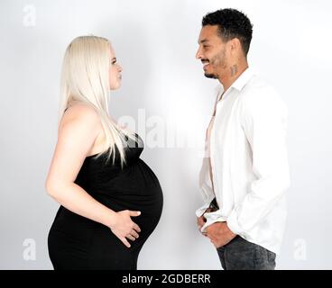 Vue profil d'un élégant et heureux couple multi-ethnique s'attendant à un bébé Banque D'Images