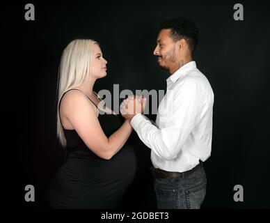 Vue profil d'un élégant et heureux couple multi-ethnique s'attendant à un bébé Banque D'Images