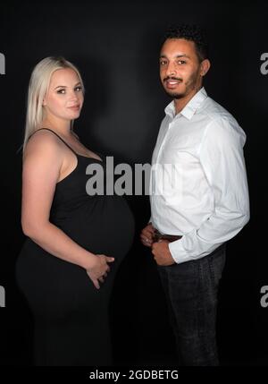 Vue profil d'un élégant et heureux couple multi-ethnique s'attendant à un bébé Banque D'Images