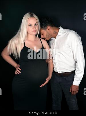 Race mixte père-à-être embrassant son épaule de femme enceinte caucasienne Banque D'Images