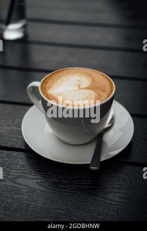 Gros plan vertical d'une tasse de cappuccino au coeur Banque D'Images