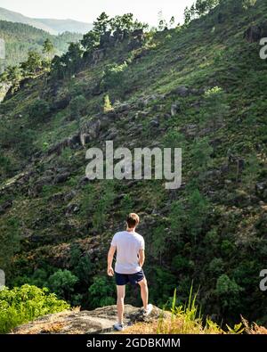 Randonneur au sommet d'une colline regardant le paysage de Gerês, une montagne à l'intérieur du Parque Nacional Peneda Gerês au Portugal. Staycation. Banque D'Images