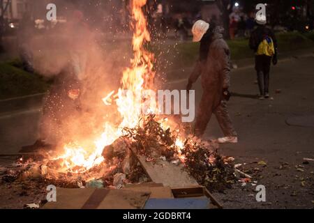 Bogota, Colombie. 11 août 2021. Les manifestants brûlent des déchets et du bois pour éviter les effets des gaz lacrymogènes alors que des affrontements se sont produits entre les manifestants et la police anti-émeute de Colombie (ESMAD) dans le nord de Bogota, en Colombie, pour admirer l'expulsion et la déforestation d'une réserve naturelle le 11 août 2021. Crédit : long Visual Press/Alamy Live News Banque D'Images