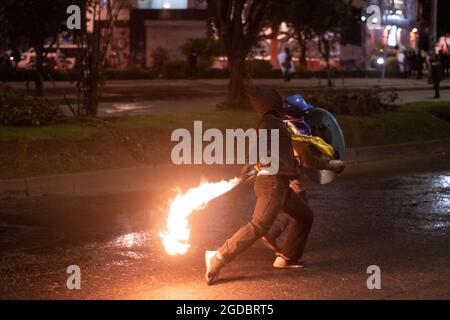 Bogota, Colombie. 11 août 2021. Un démonstrateur lance une bombe molotov à la police alors que des affrontements se sont produits entre les manifestants et la police anti-émeute de Colombie (ESMAD) dans le nord de Bogota, en Colombie, pour admirer l'expulsion et la déforestation d'une réserve naturelle le 11 août 2021. Crédit : long Visual Press/Alamy Live News Banque D'Images