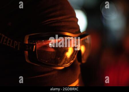 Bogota, Colombie. 11 août 2021. Un membre de première ligne voit un foyer réfléchi sur ses lunettes alors que des affrontements se dressent entre les manifestants et la police anti-émeute de Colombie (ESMAD) dans le nord de Bogota, en Colombie, et admiré l'expulsion et la déforestation d'une réserve naturelle le 11 août 2021. Crédit : long Visual Press/Alamy Live News Banque D'Images