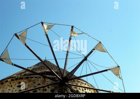 Grèce, l'île de Santorini. Un moulin à vent solitaire. Les voiles blanches contrastent avec le ciel bleu profond de l'été. Tradition et nature. Banque D'Images