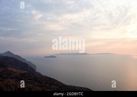 Grèce l'île de Sikinos. Un doux coucher de soleil sur l'île voisine de Folegandros. Une soirée d'été chaude et atmosphère. Banque D'Images