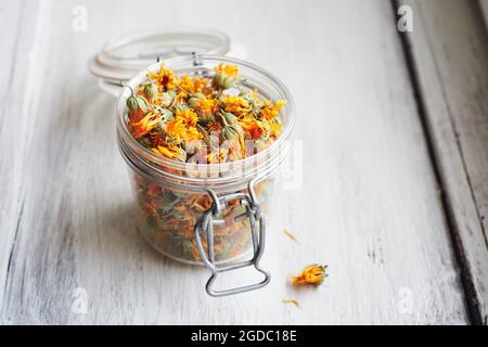 Fleurs de marigold séchées dans un pot sur bois blanc, foyer sélectif. Banque D'Images
