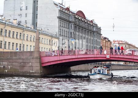 Saint-Pétersbourg, Russie - vers mai 2021 : un petit bateau de plaisance passe sous le pont sur la rivière Fontanka. Les touristes voyagent sur les bateaux de plaisance et de voir les s. Banque D'Images