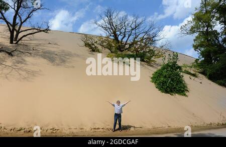 Mount Baldy est une dune de sable mobile. Il est déplacé par le vent chaque année. Une femme plus âgée se tient au pied de la dune pour montrer à quel point elle est grande. Banque D'Images