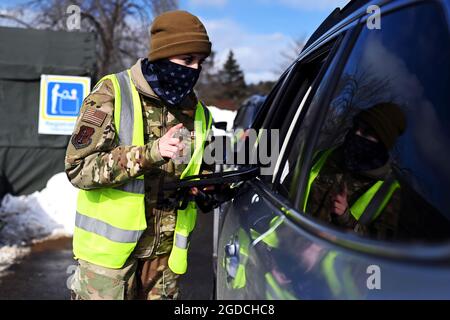 Un aviateur de 1re classe Victoria Moquin, un officier des forces de sécurité du 157e Escadron des forces de sécurité, NHANG, enregistre un patient le 11 février 2021 à un site de vaccination au drive à Concord, N.H. Le site, situé dans le parking d'un centre commercial, administre des centaines de tests et de vaccins COVID-19 par jour. (É.-U. Photo de la Garde nationale aérienne par le sergent d'état-major. Charles Johnston) Banque D'Images