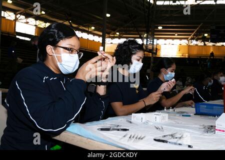 Le personnel médical de la Marine américaine prépare des vaccins COVID-19 à Bloch Arena, joint base Pearl Harbor-Hickam, Hawaii, le 10 février 2021. Les membres du service ont reçu volontairement la vaccination dans le but d'accroître l'état de préparation de l'unité et d'assurer la sécurité de leurs collègues. Le vaccin COVID-19 est administré dans une série de deux doses séparées par trois à quatre semaines. (É.-U. Corps maritime photo par lance Cpl. Danny Nateras) Banque D'Images