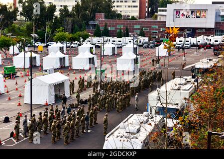 Des gardiens de la Garde nationale de Californie affectés à la Force opérationnelle interarmées Mustang assistent à un briefing du matin sur le campus de l'Université d'État de Californie à Los Angeles, le 15 février 2021. La force a été mise en service pour soutenir le premier site de distribution du vaccin COVID-19 de l’Agence fédérale de gestion des urgences et du Bureau des services d’urgence du gouverneur de la Californie. (É.-U. Photo de la Garde nationale aérienne par le principal Airman Neil Mabini) Banque D'Images