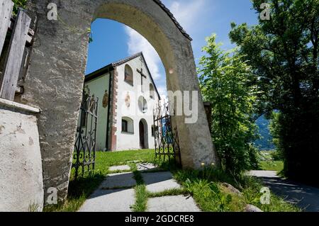 Porte d'entrée ensoleillée de la petite église de village de la région alpine de montagne à Mieming, Tirol, Autriche Banque D'Images