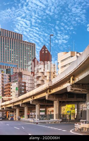 tokyo, japon - juillet 05 2021 : autoroute Shuto dans le quartier de Shimbashi avec le bâtiment emblématique de la Tour de capsule de Nakagin surmontée d'un crea sur toit rouillé Banque D'Images