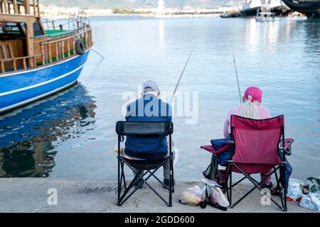 Turquie, Alanya - 9 novembre 2020 : un couple âgé pêche dans le port d'Alanya. Loisirs et style de vie agréables des retraités. Banque D'Images