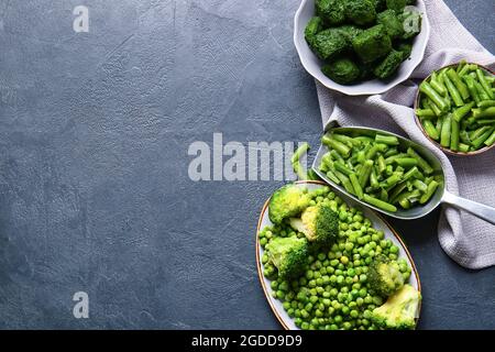 Composition avec légumes verts congelés sur fond sombre Banque D'Images