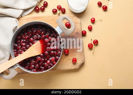 Préparation d'une savoureuse confiture de cerises sur fond de couleur Banque D'Images