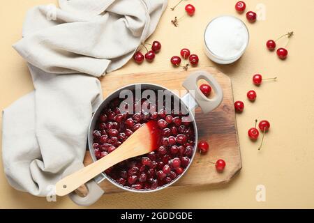 Préparation d'une savoureuse confiture de cerises sur fond de couleur Banque D'Images