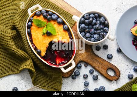 Composition avec cordonnier aux myrtilles dans un plat de cuisson sur fond clair Banque D'Images