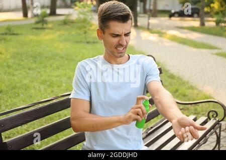 Jeune homme avec répulsif anti-moustiques à l'extérieur Banque D'Images