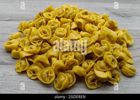 Tortellini frais cru sur une table en bois. Cuisine italienne Banque D'Images