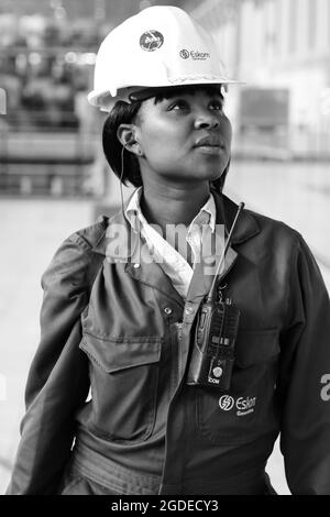 JOHANNESBURG, AFRIQUE DU SUD - 06 janvier 2021 : échelle de gris d'une femme africaine dans une salle de turbine de la centrale électrique de combustion de charbon Banque D'Images