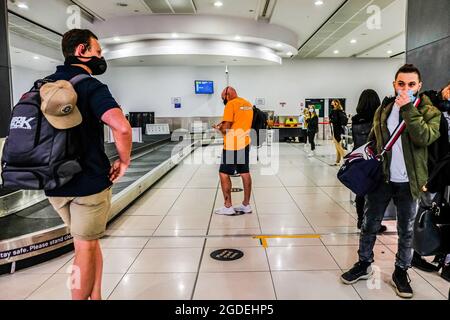 Melbourne, Australie. 19 mai 2021. Les personnes portant des masques pour prévenir la propagation du coronavirus attendent leurs bagages au carrousel à bagages de l'aéroport de Melbourne. (Credit image: © Alexander Bogatirev/SOPA Images via ZUMA Press Wire) Banque D'Images