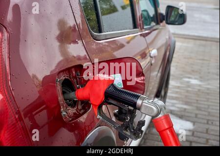 le pistolet est inséré dans le réservoir de gaz de la voiture Banque D'Images