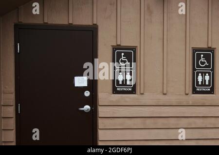 Hellbraunes, öffentliches Toilettenhäuschen an einem Rastplatz im Denali Nationalpark en Alaska, Etats-Unis. Banque D'Images