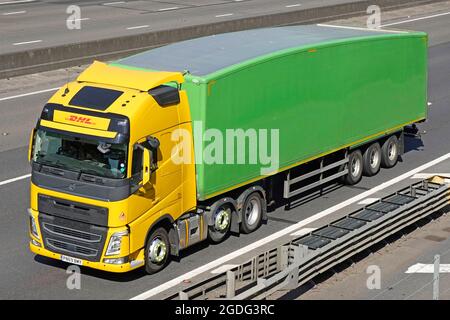 Vue avant et vue sur le camion hgv exploité par DHL livraison d'un colis de messagerie et courrier express pour le remorquage d'une remorque articulée non marquée verte au Royaume-Uni Banque D'Images