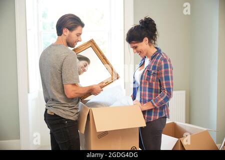 En miroir couple packing cardboard box Banque D'Images