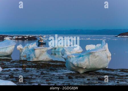 Petit bateau amarré parmi de grands morceaux de glace de mer, Iqaluit, Canada. Banque D'Images