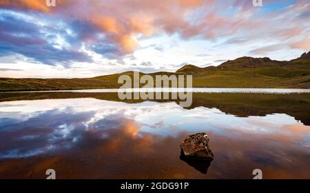 Reflet du ciel au coucher du soleil dans le lac miroir d'Écosse avec des collines de bruyère Banque D'Images
