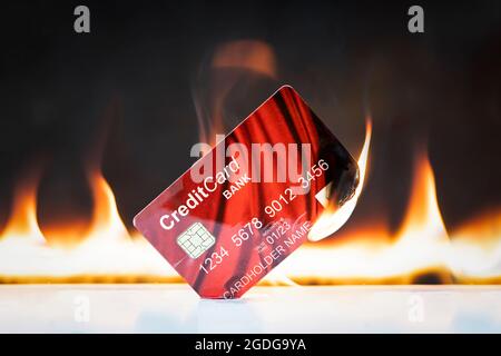 Carte bancaire en flammes sur fond noir. Concepts de l'effondrement des marchés financiers et du système de crédit et financier. Sanctions et disco Banque D'Images