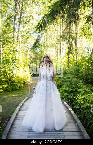 Belle jeune femme en robe blanche debout dans la nature. Banque D'Images