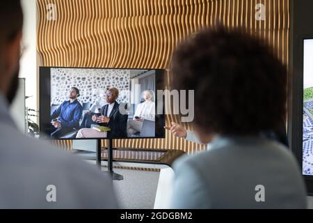 Les employés qui regardent le moniteur pendant la visioconférence avec divers collègues Banque D'Images