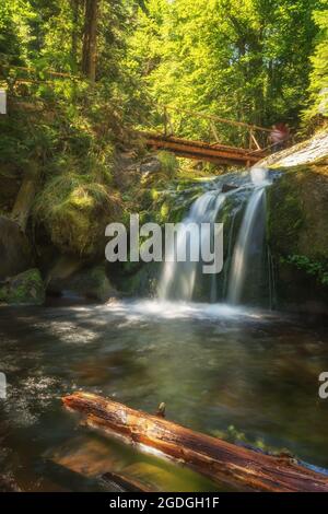 Des cascades mousseuse bouillonnantes sous un pont en bois. Banque D'Images