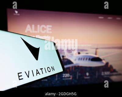 Téléphone mobile avec logo de la compagnie d'avions électriques Eviation Aircraft Ltd. À l'écran devant le site Web. Effectuez la mise au point au centre-droit de l'écran du téléphone. Banque D'Images