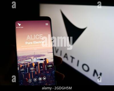 Personne tenant un smartphone avec le site Web de la compagnie d'avions électriques Eviation Aircraft Ltd. À l'écran avec le logo. Concentrez-vous sur le centre de l'écran du téléphone. Banque D'Images