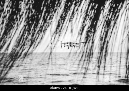 Drone avec caméra numérique haute résolution survolant le spectaculaire ciel de coucher de soleil sur la plage - Drone survolant la plage pour la sécurité de peopl Banque D'Images