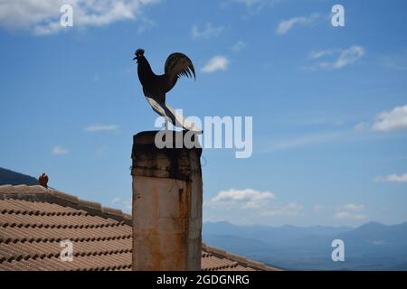 Cheminée de maison rurale avec une girouette de fer traditionnelle sur un toit en tuiles d'argile à Dimitsana Arcadia, Péloponnèse Grèce. Banque D'Images