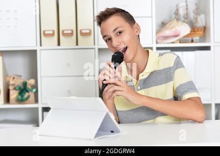 Portrait of teenage girl singing karaoke at home Banque D'Images