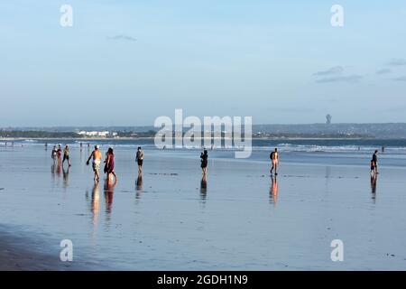 Kuta, Indonésie - 14 septembre 2018 : les touristes et les habitants de la région se promènent et profitent du coucher du soleil sur la plage de Seminyak à Bali. C'est l'une des attractions touristiques dans Banque D'Images